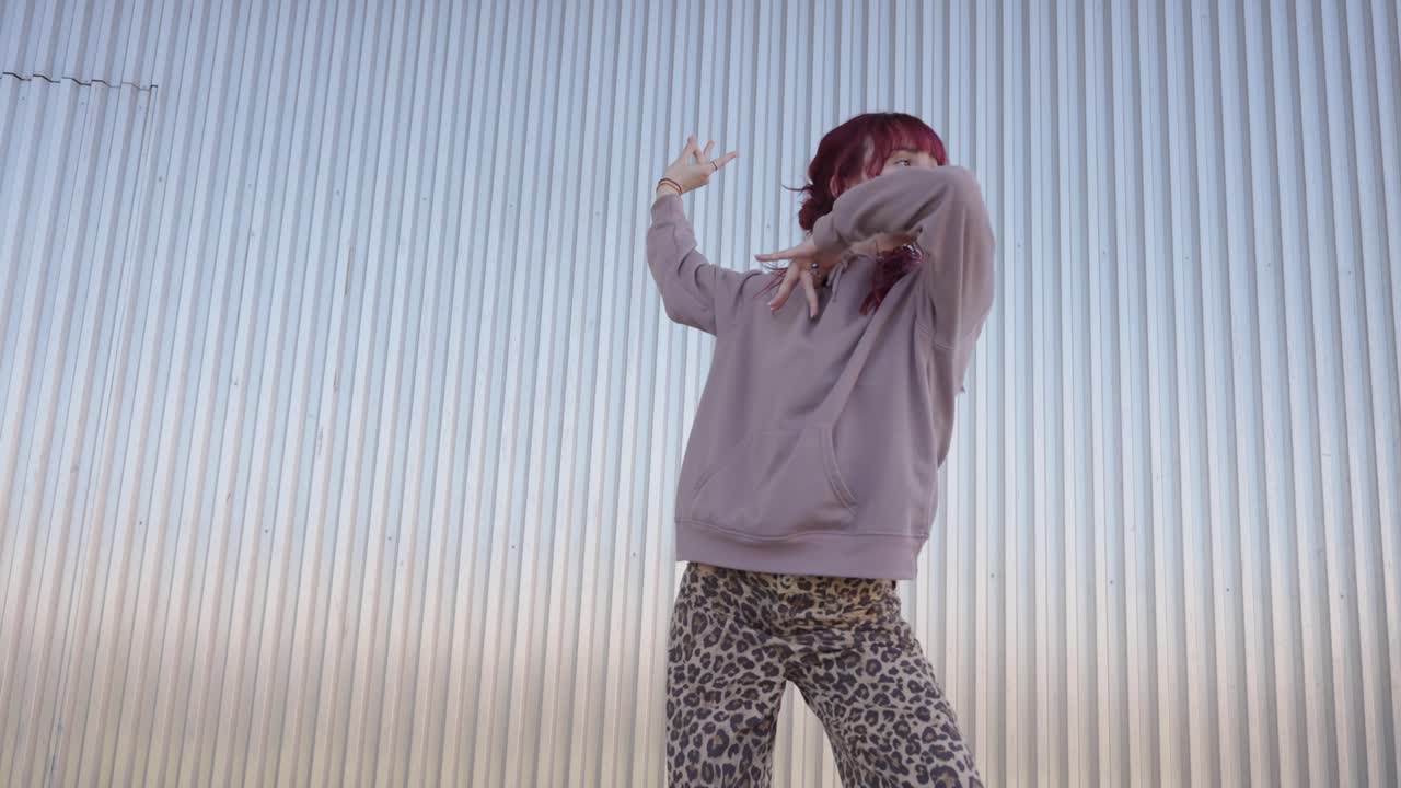 Young urban dancer performing in front of metal wall