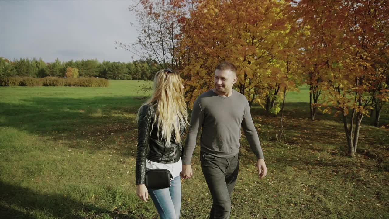 Una pareja caminando en el parque de otoño.