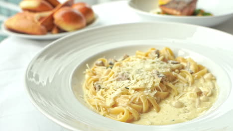 close-up of crumbles of cheese dropped onto a plate of pasta