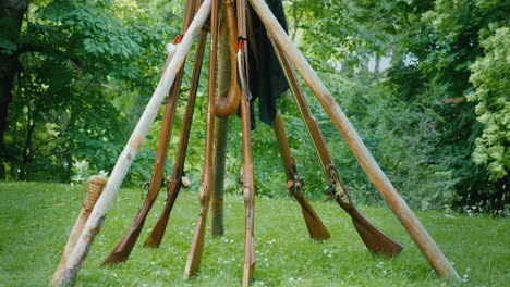 a pyramid of old rifles standing in the forest camp during the development of the american continent