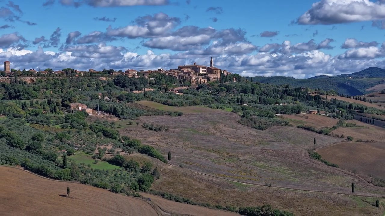 Pienza, Toscana, Italia, tempo soleggiato con nuvole cumuliformi timelapse, hyperlapse con drone teleobiettivo