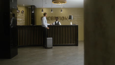 hombre acercándose a la recepción del hotel