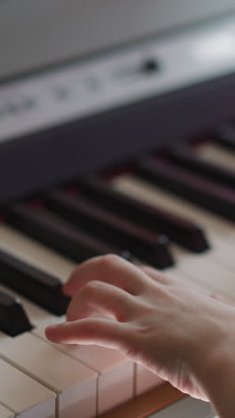 schoolgirl with absolute pitch plays synthesizer. girl presses keys smoothly and skillfully creating harmonious melody closeup on blurred background