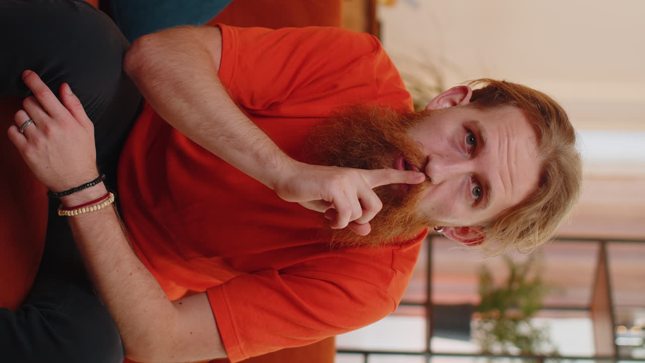 el joven presiona el dedo a los labios hace silencio signo de silencio no dice chismes secreto, tranquilo en casa