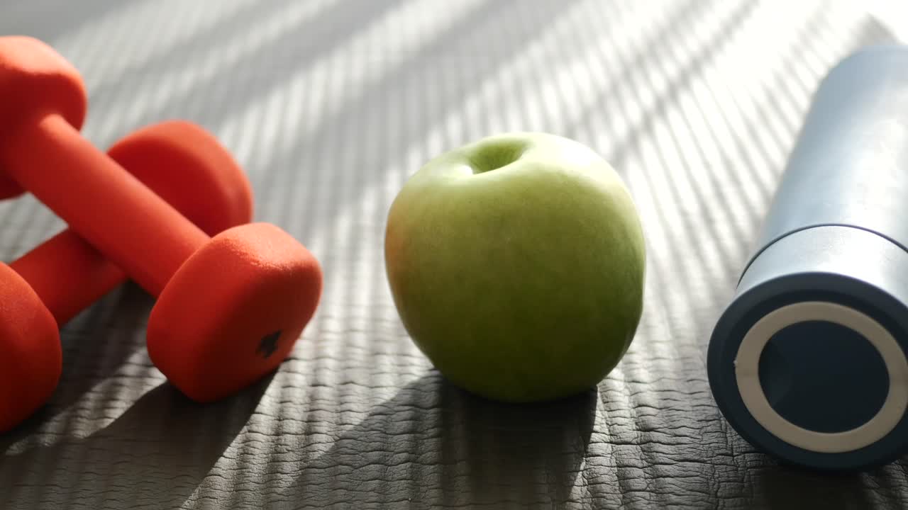 Dumbbells and an apple for a healthy lifestyle