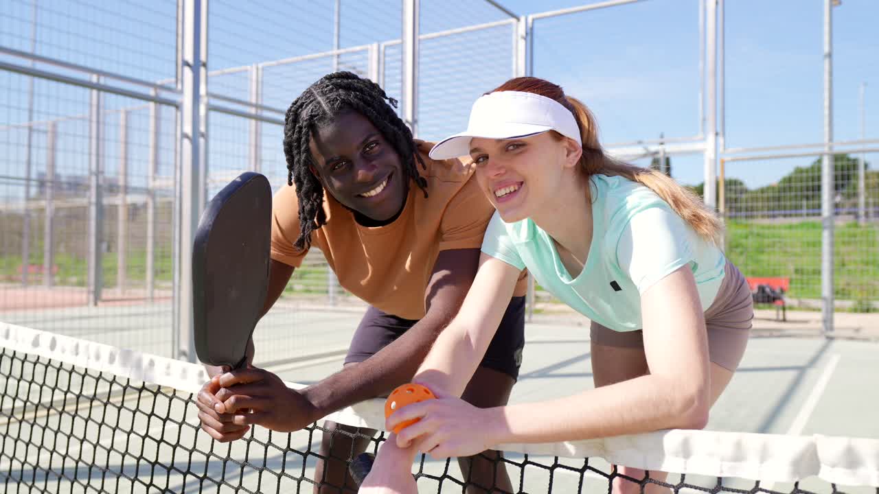 Happy Man and Woman Posing on Padel Court with Rackets and Ball