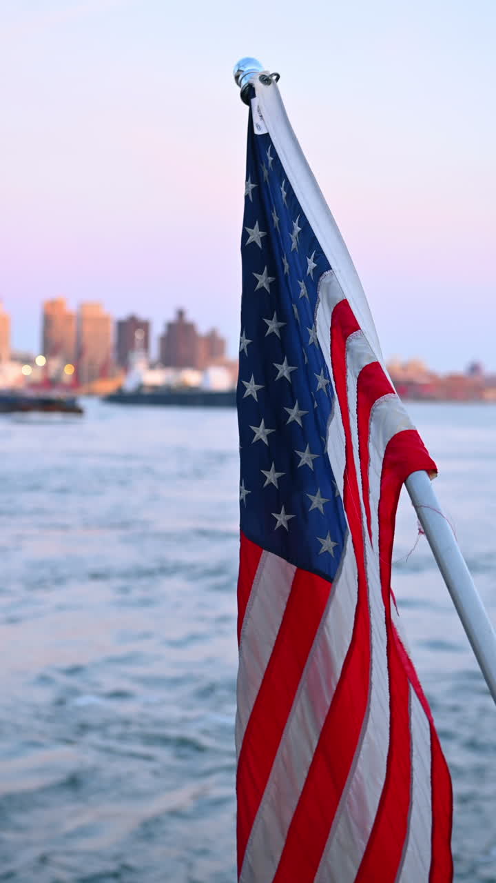 Bandiera americana su una barca vicino al lungomare di New York. Primo piano di una bandiera americana su una barca con New York sullo sfondo