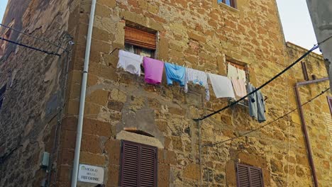 Calle-Típica-Con-Tendedero-Colgado-En-El-Pueblo-Medieval-De-Pitigliano-En-Toscana,-Italia