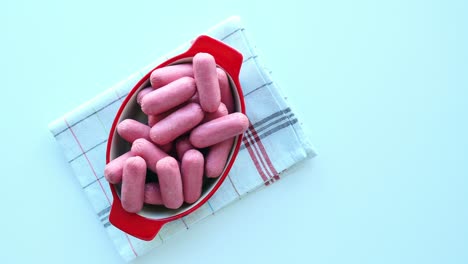 salchichas rosas en un cuenco rojo