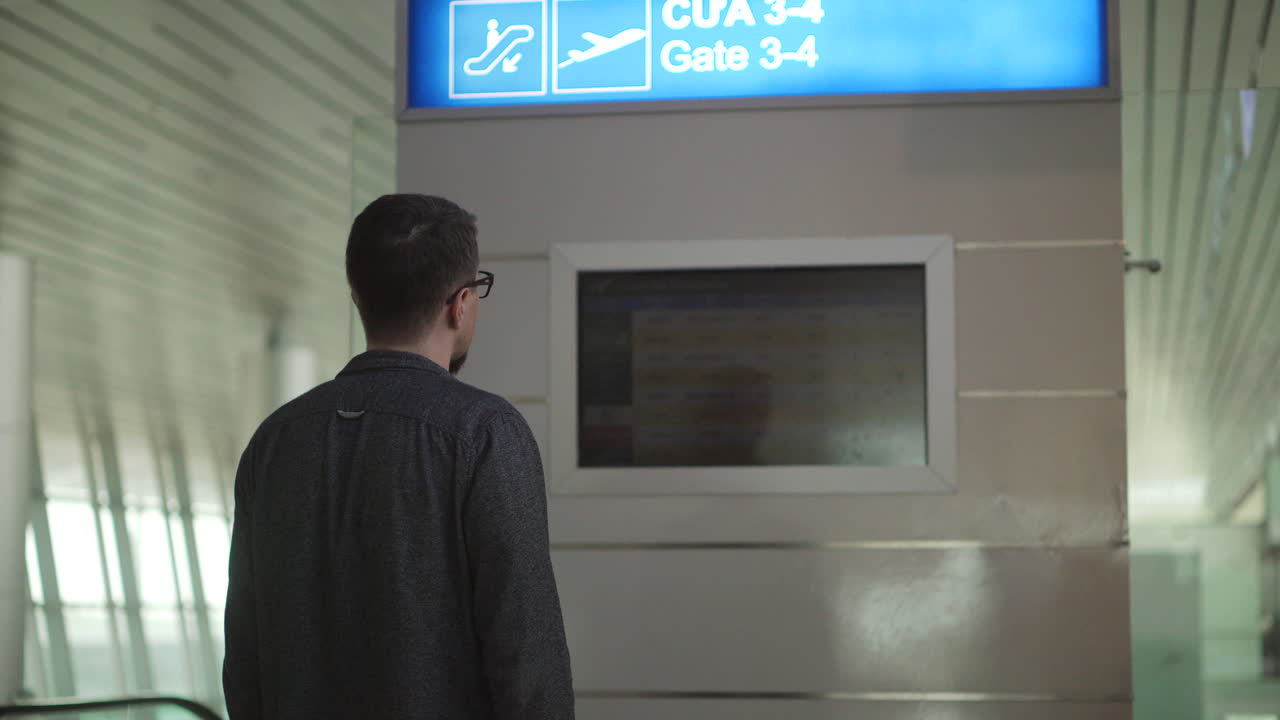 Man looking at airport information display