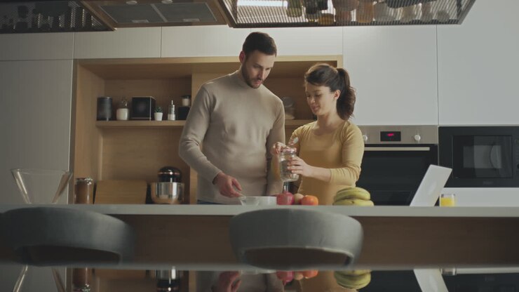 пара готовит завтрак вместе на современной кухне