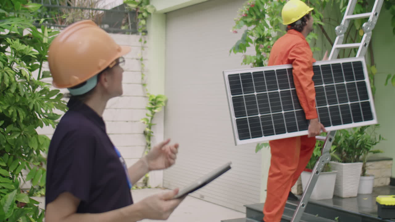 Female Engineer Controlling Worker Installing Solar Panel on Rooftop