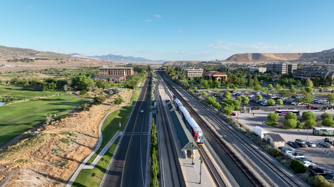 Frontrunner commuter train at Lehi Station in Utah ready to leave southbound for Provo on a sunny morning - aerial flyover