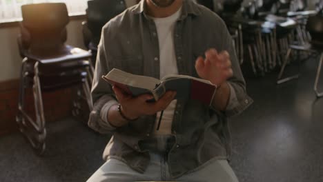 hombre leyendo la biblia en un aula