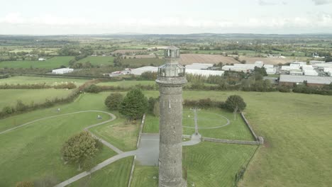 Lloyd-Tower-in-Kells,-Ireland,-showcasing-the-historic-structure-amid-green-fields,-aerial-view