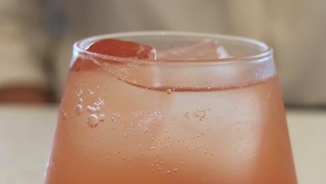 primer plano de una bebida rosada con hielo