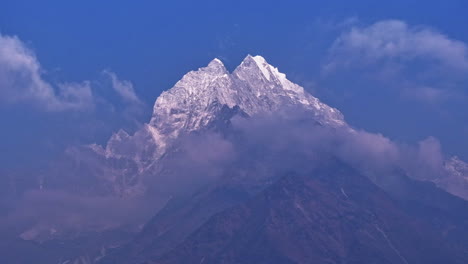 timelapse drone shot of clouds drifting past mount everest in nepal, revealing less snow peaks and landscape affected by global warming
