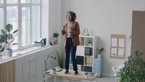 woman dancing on desk in modern office