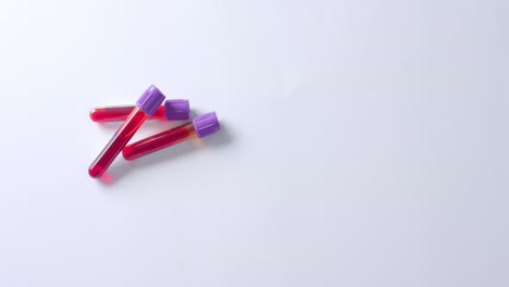 close up of blood samples on white background with copy space, slow motion