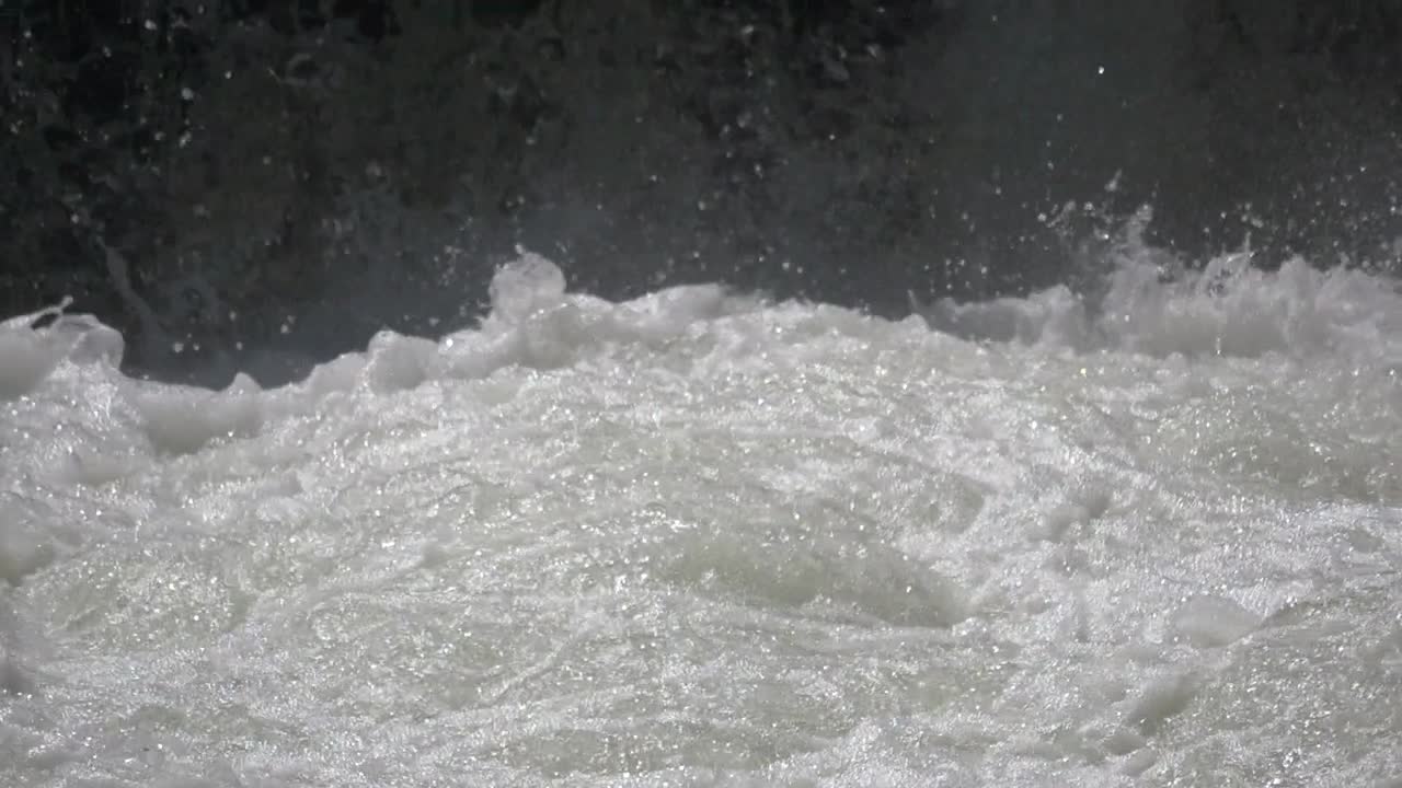 Slow Motion close up of splashing natural waterfall in nature during sunny day