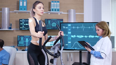 female athlete runs on treadmill with electrodes attrached on her body