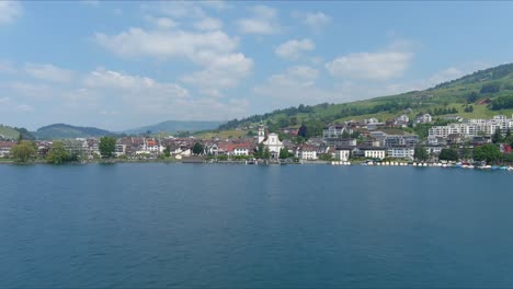 kussnacht flyover: moviéndose sobre el pintoresco valle de agua y el pueblo en las montañas de los alpes, suiza, europa, avión no tripulado | dramática toma cinematográfica de reversión de una pequeña ciudad aledaña a lo largo de un vasto lago y el campo