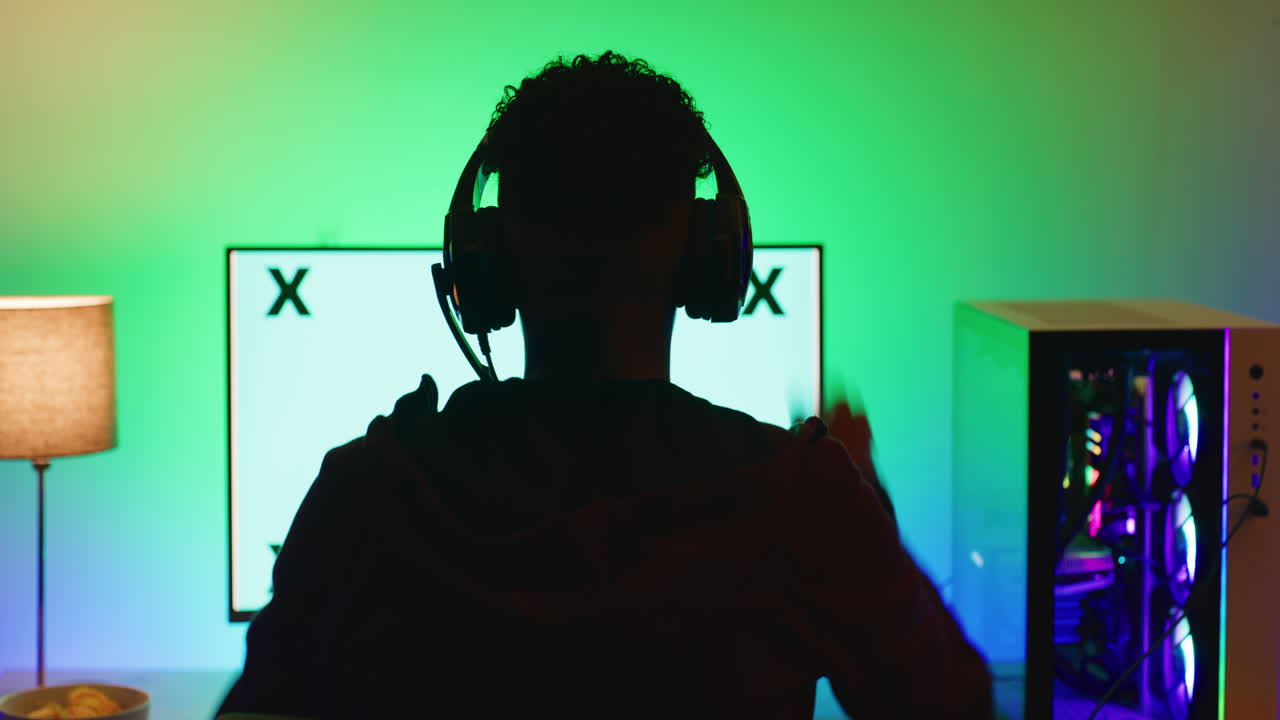 Back view of a computer gamer wearing headphones