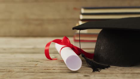 video of paper roll with ribbon and books on wooden surface