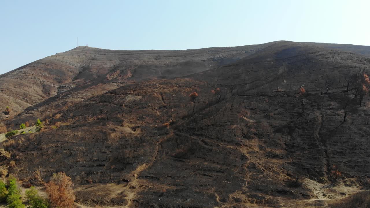 montaña quemada por el fuego cubierta de ceniza negra, no quedan árboles después de la catástrofe
