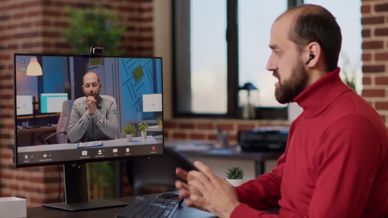Businessman attending remote videocall meeting on computer