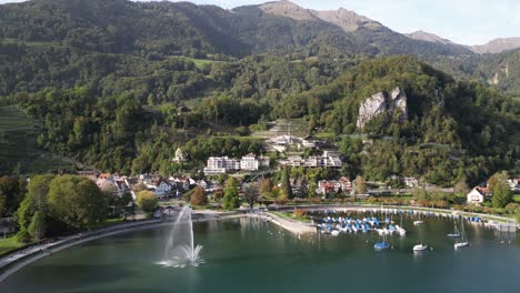 Schwenk-Von-Links-Nach-Rechts-Eines-Sees-Mit-Sportmöglichkeiten-Und-Springbrunnen-Im-Tal-Inmitten-Der-Dicht-Bewaldeten-Hügel