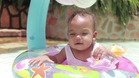 una toma cercana de un bebé divirtiéndose en un dispositivo de flotación en una piscina para niños