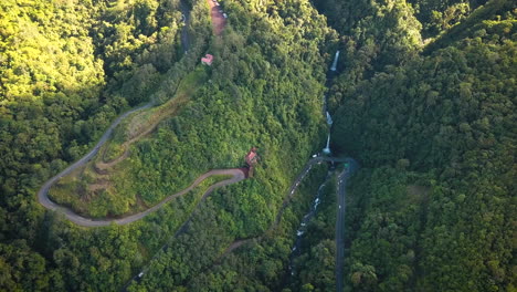 sinuosos caminos de tierra y hermosas cascadas en un valle de río tropical