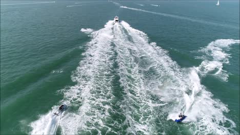 jetski jumping over a motorboat wake