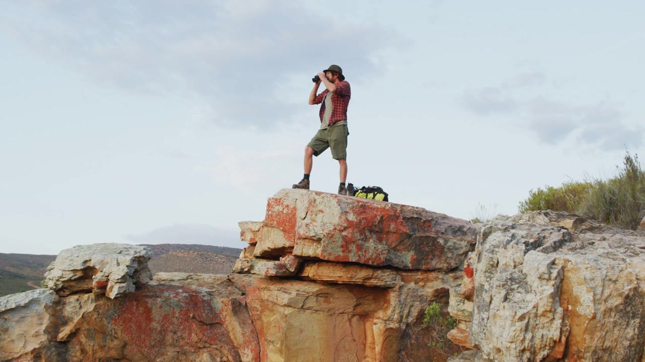 Hiker on cliff scanning horizon with binoculars, social badges appearing, clustering, then fading