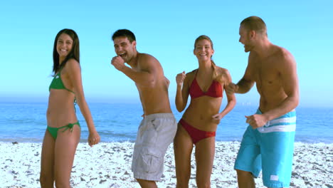 un grupo de amigos bailando en la playa