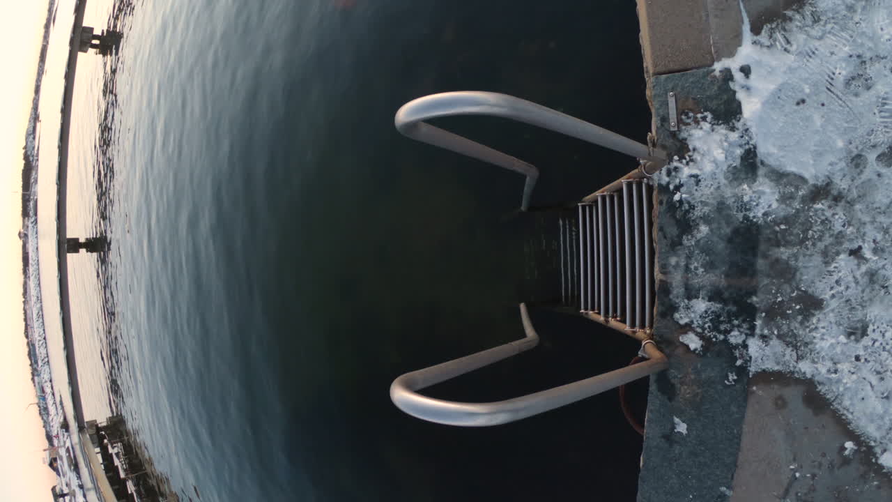 추운 겨울날 스웨덴 예테보리에서 항구 항구 옆에 있는 금속 계단의 4k 세로 샷