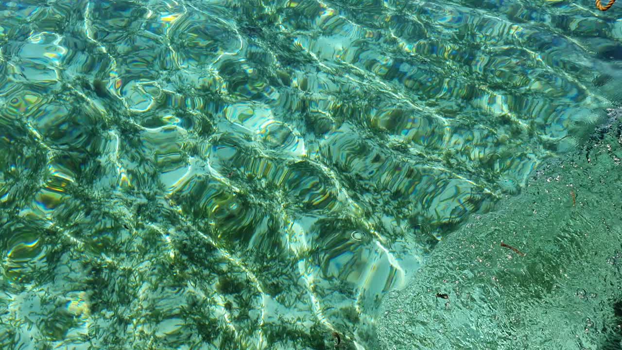 맑고 푸른 물과 아래의 모래를 내려다보며 천천히 움직이는 배의 측면에서 보기