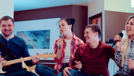 amigos divertidos cantaban canciones y tocaban la guitarra en casa.