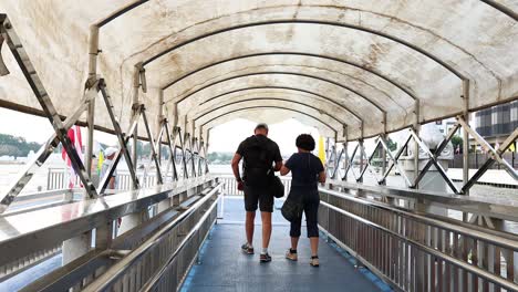 couple strolls along pier in bangkok