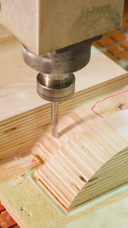máquina cnc dinámica de perforación en madera contrachapada, asegurada por pinzas en una mesa a cuadros