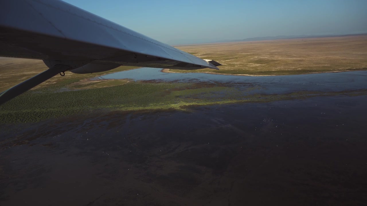 Luftfoto fra safarifly af Amboseli-søen i Kenya. Smukt, frodigt afrikansk landskab set fra oven fra et fly, der flyver over det afrikanske landskab i et lille fly.