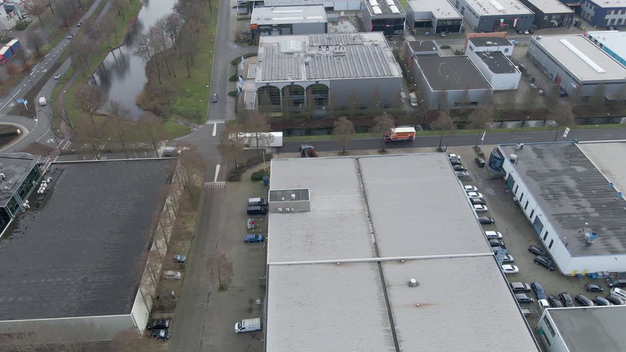 Luftfoto af lastbiler og biler, der kører på travlt industriområde