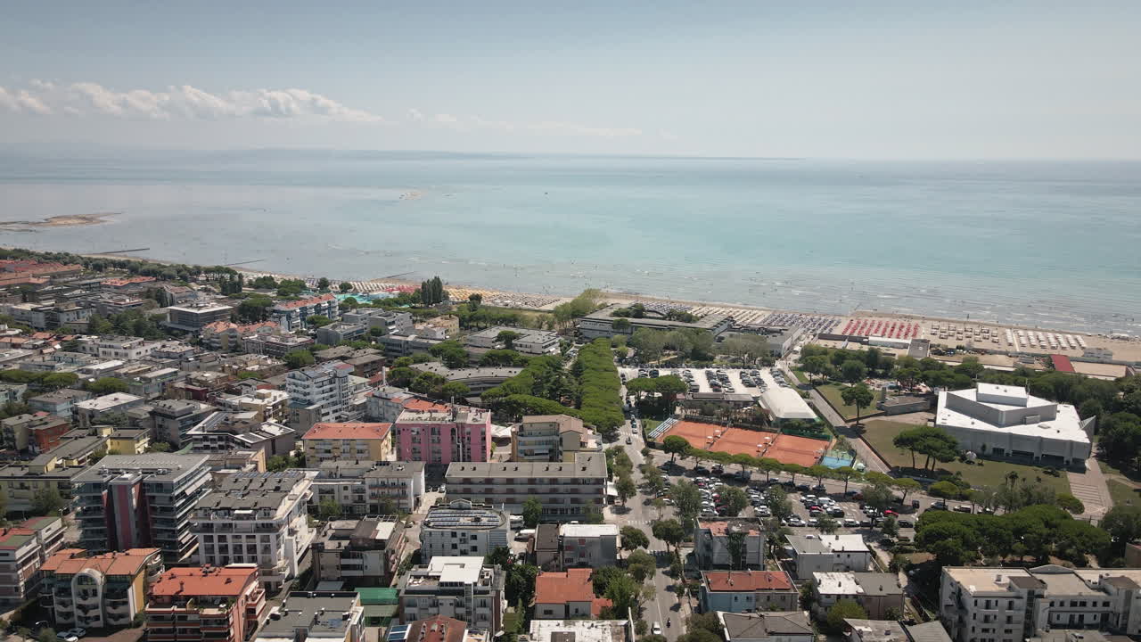 Drone 4K UHD che vola fluidamente in avanti attraverso la Laguna di Grado verso lo skyline della città costiera e il porto turistico, creando puliti filmati b-roll di ambientazione per pubblicità di viaggi, promozioni, film