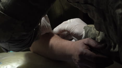 a military doctor fits an intravenous access device to a ukrainian soldier suffering concussion at a frontline stabilisation point field hospital at an undisclosed location.