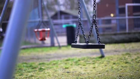 playground during covid-19 coronavirus pandemic lockdown, empty swing swinging in slow-motion, missing child