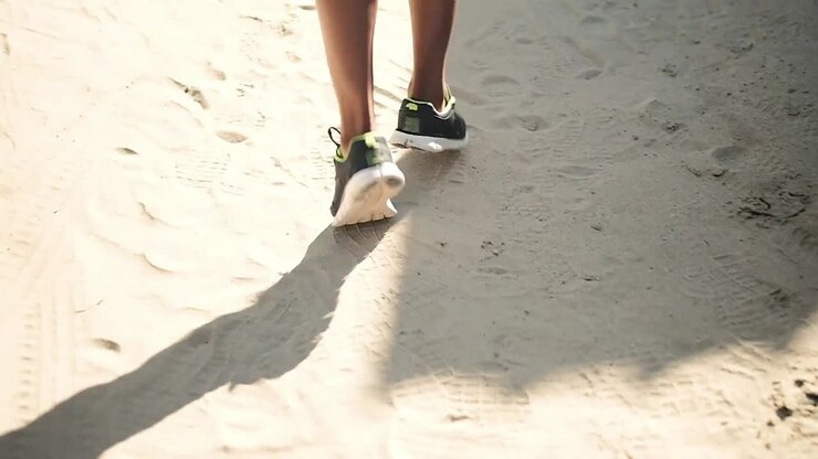 Low section of man running on the beach