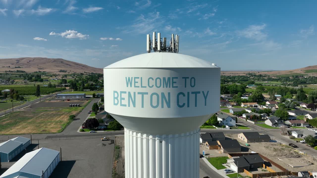 Lowering drone shot of Benton City's welcome message on their water tower