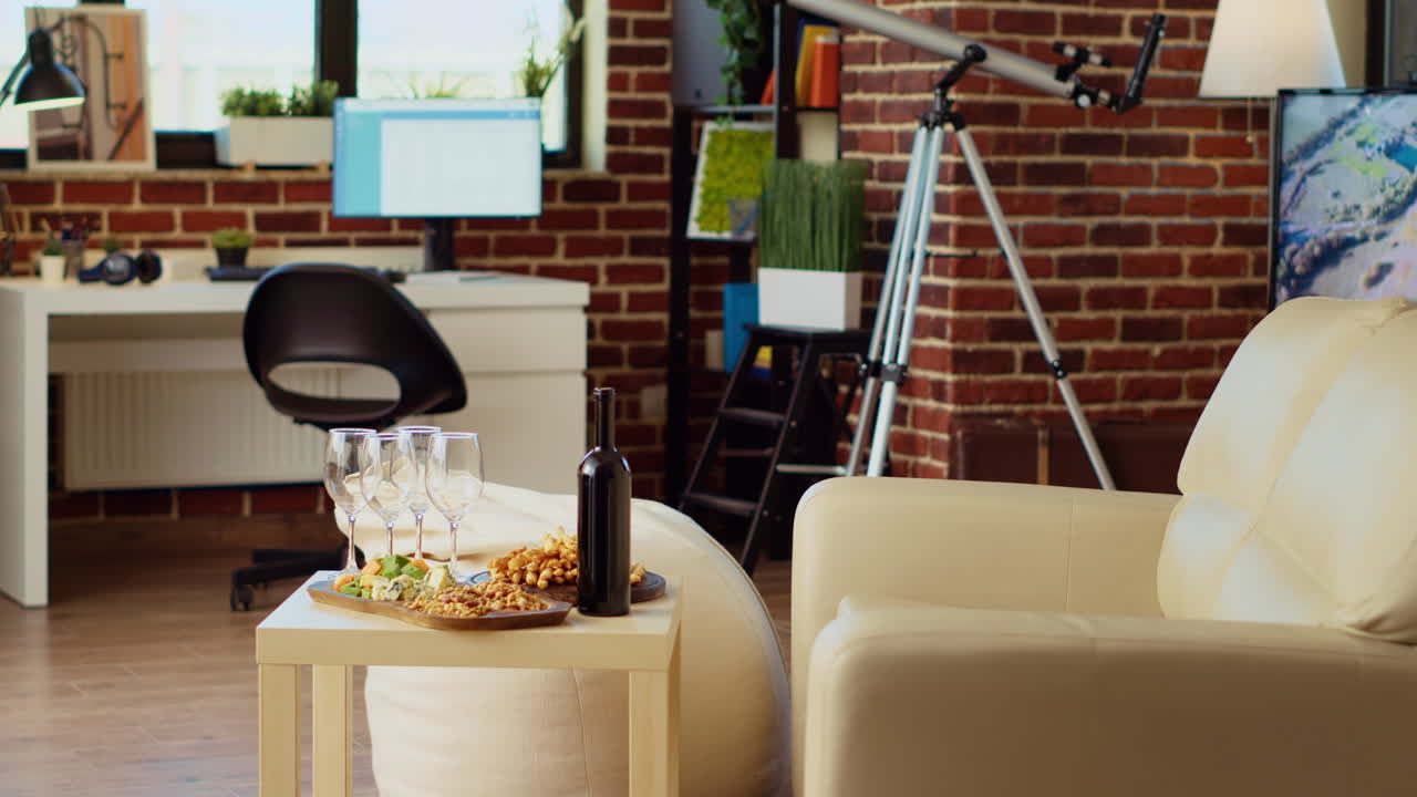 Panning shot of charcuterie board on stylish living room table next to bottle of expensive wine