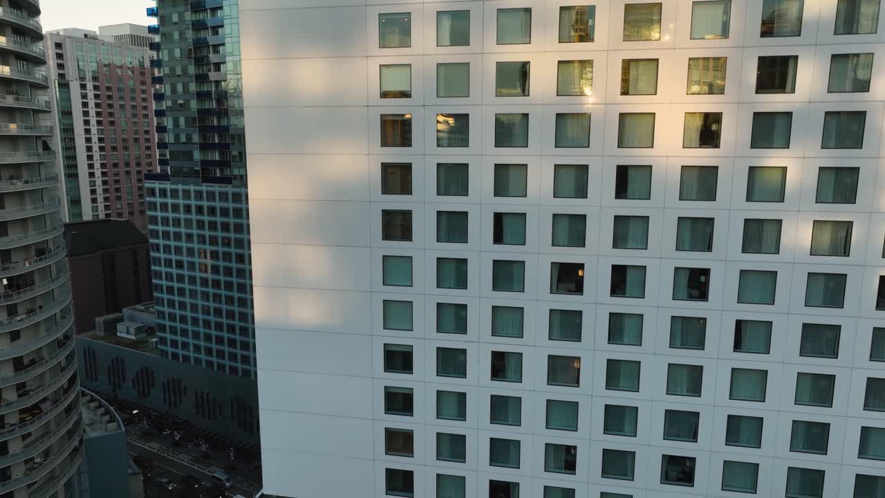 las ventanas de un rascacielos reflejan la puesta de sol en seattle, el ascenso aéreo